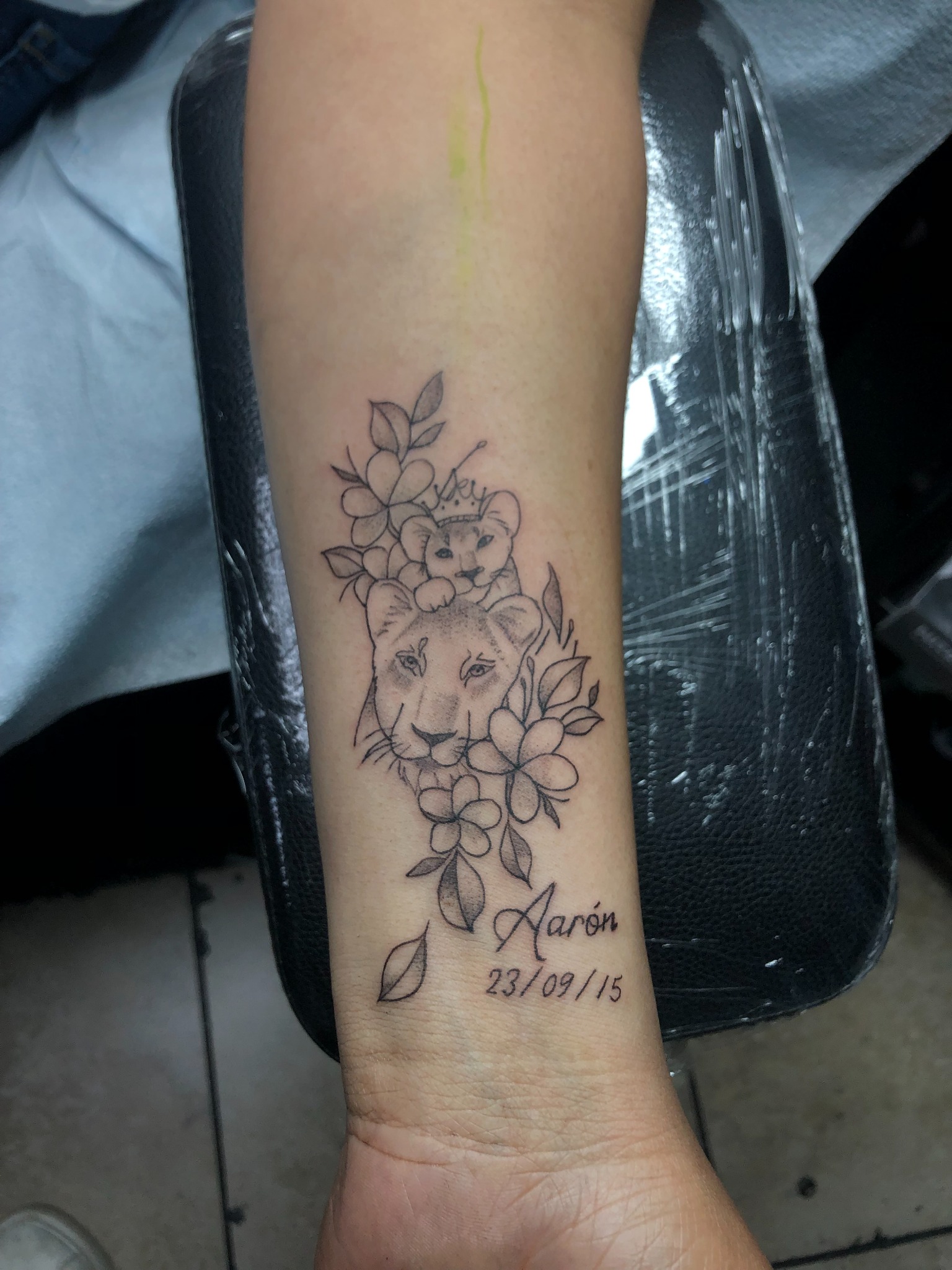 Fine line lion family and floral memorial forearm tattoo by Blady
